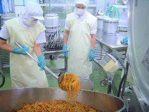 中学生が食缶にもりつける