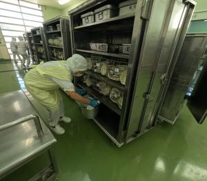 食缶をコンテナに入れる