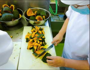 かぼちゃを包丁で切っています。